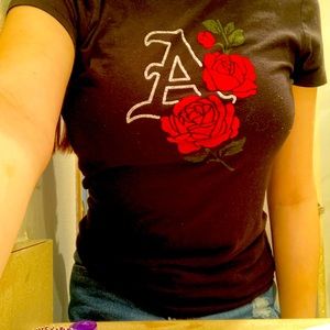 Black shirt with three roses on it and an A